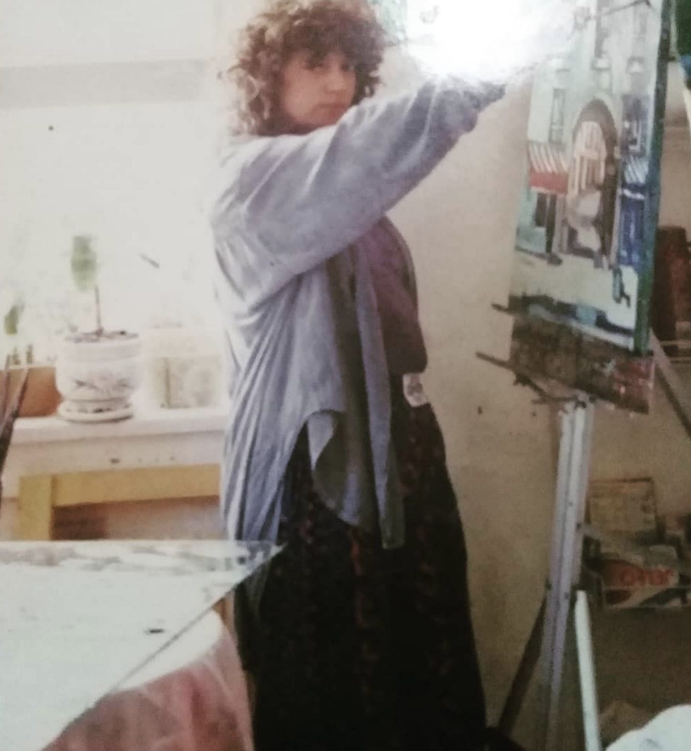 Yvonne Mora painting at her easel in the studio